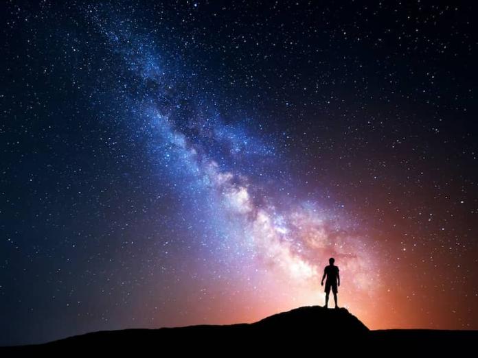 A silhouette of a person looking at the Milky Way.