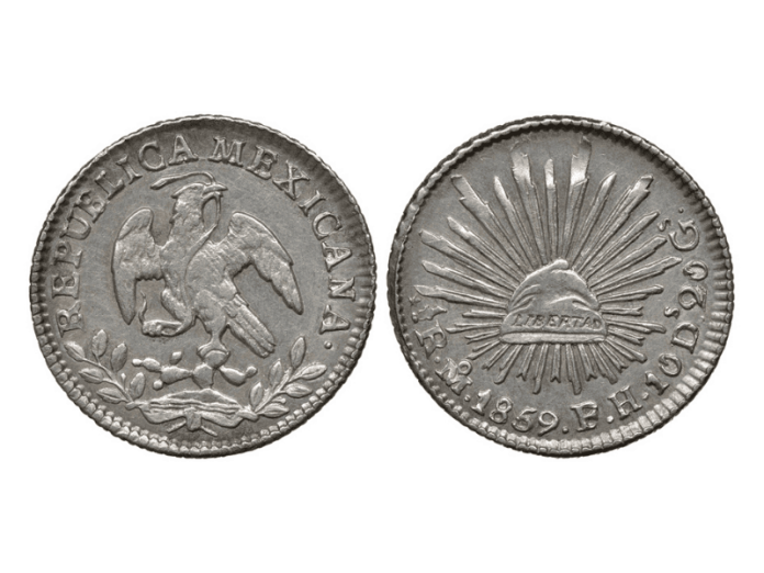 The front and back of a Mexican coin showing an eagle and the sun