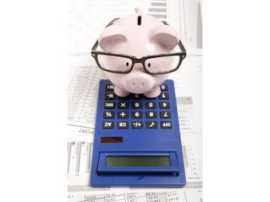 A piggy bank and calculator on a desk, representing budgeting and saving money
