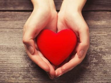 a woman holding out a heart symbolizing sensitivity 