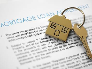 A set of house keys placed on a mortgage loan document