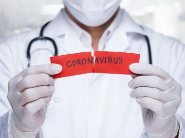 a doctor holding a piece of paper that says coronavirus