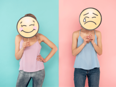 woman holding smile emoji and frown emoji