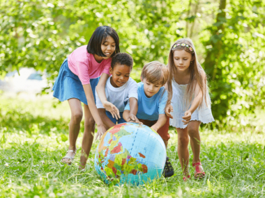 group of multicultural children playing with a globe
