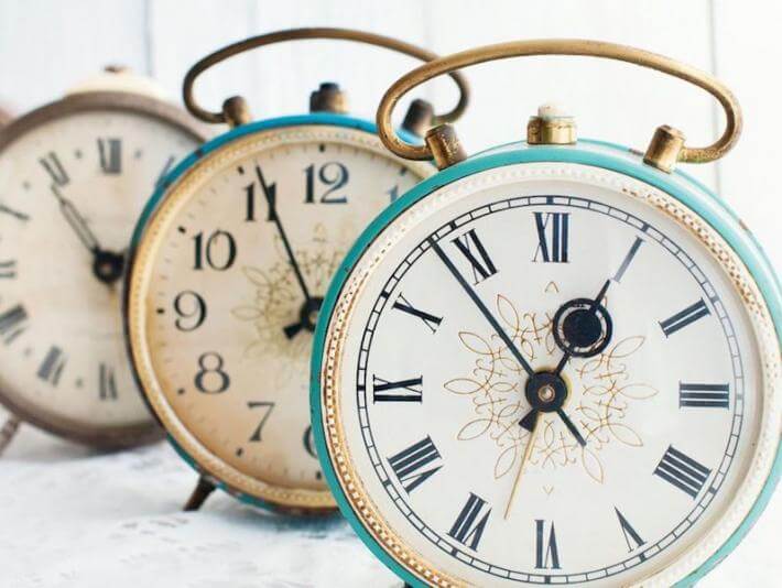 Clocks to illustration the difference between momentarily and in a moment