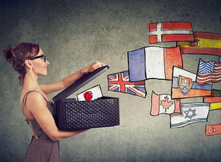 A woman opening a box of flags as if she is setting languages free through translation