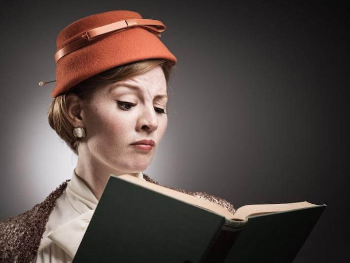 a woman reading a book of quotations