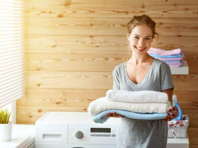 image of woman doing laundry for a large family