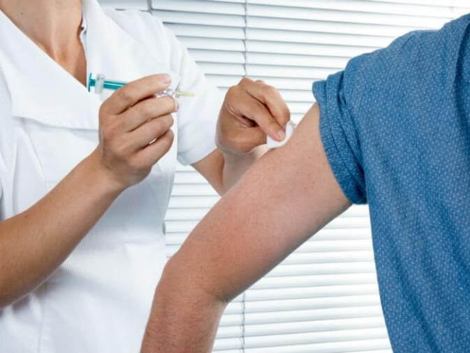 image of doctor administering a vaccine