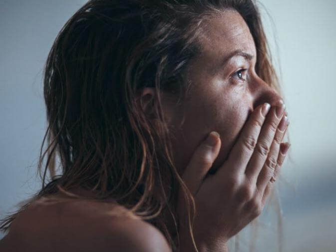 image of woman holding back tears