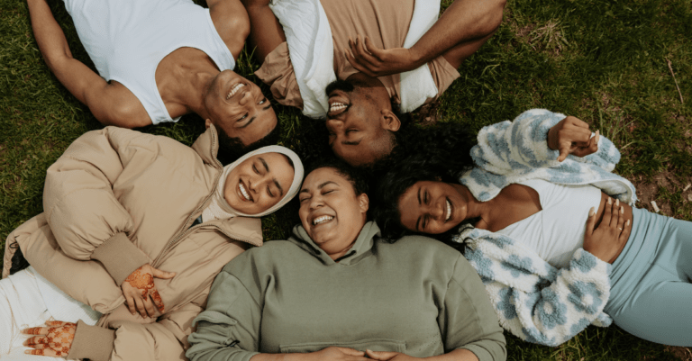 a group of friends laying in a circle and laughing