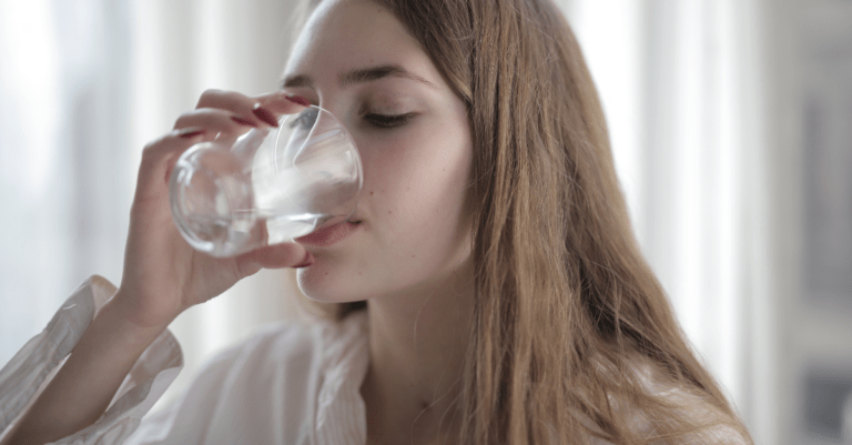 Can You Compensate for a High Sodium Diet? a woman drinking from a glass