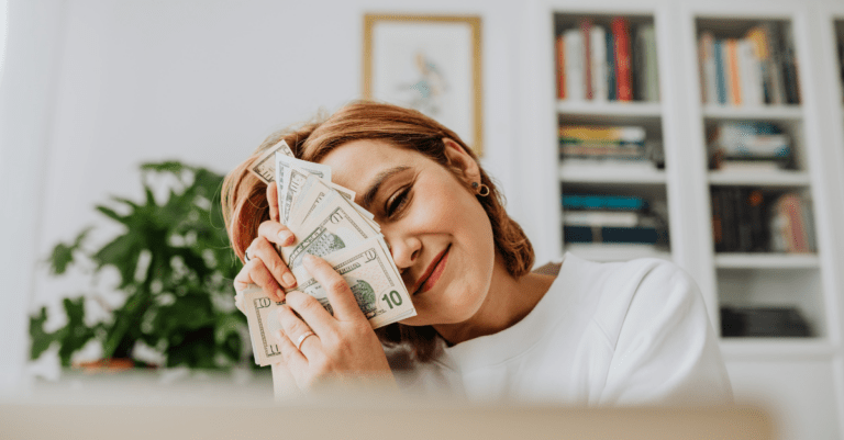 a woman fanning out money and holding it in front of her