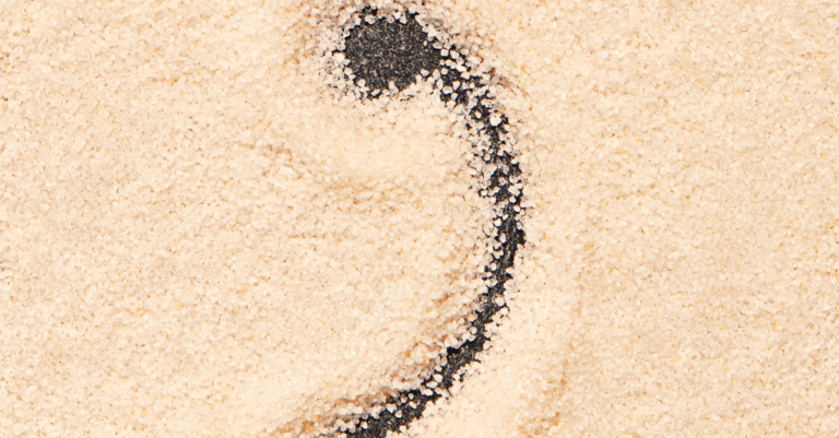 a comma etched in sand