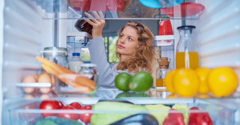 woman looking in her refrigerator