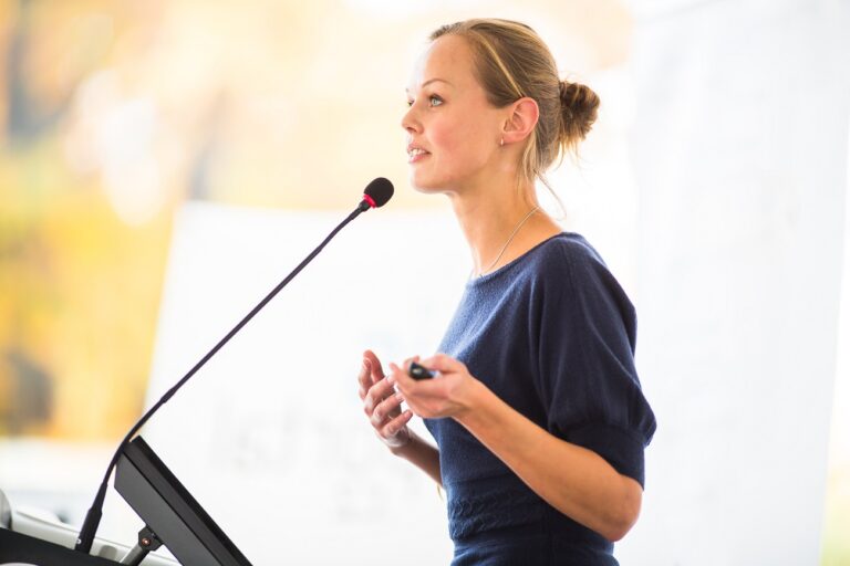 Woman at a microphone giving a speech.