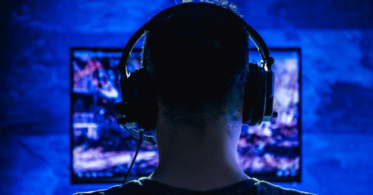 a man with headphones sitting in front of a videogame screen