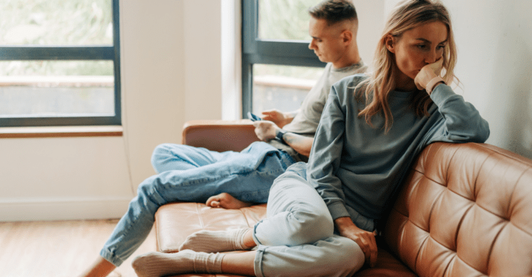 unhappy couple sitting on the couch