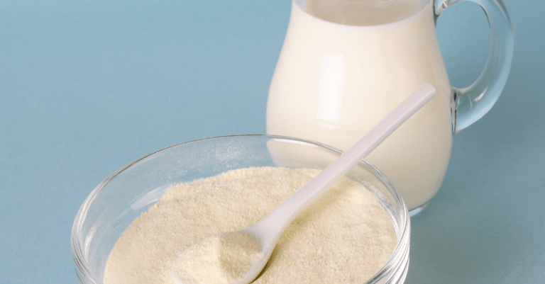 a pitcher of milk next to a bowl of powder