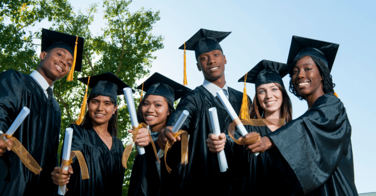 a group of graduates holding their diplomas out