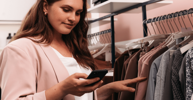 a woman shopping and looking down at her smartphone