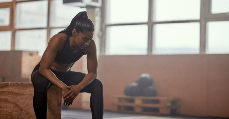 a woman sitting and resting in the gym