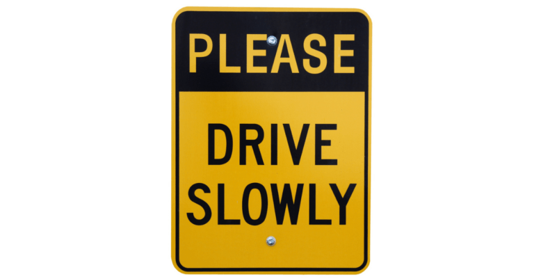 A black and yellow road sign that reads please drive slow. Isolated on a white background.