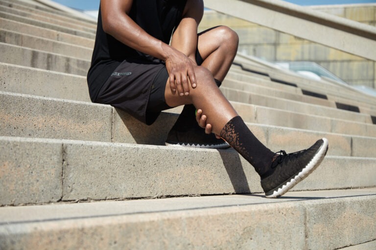 Person on bleachers rubbing leg