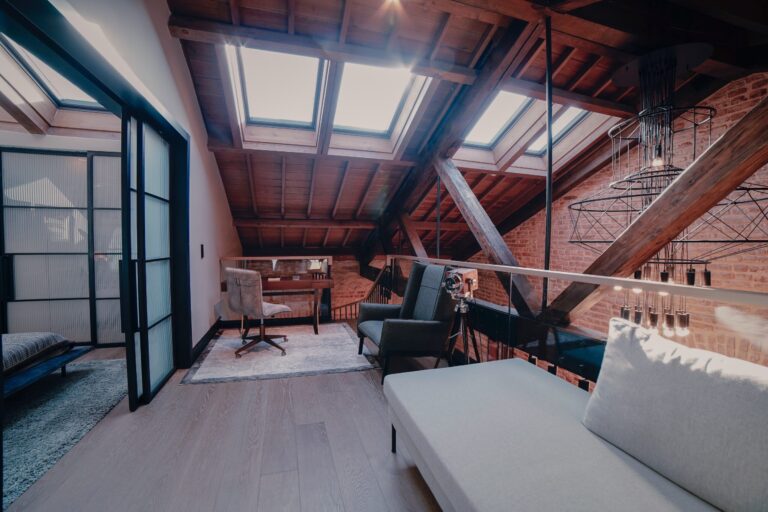 Room with high, wood paneled ceilings, couch and chair