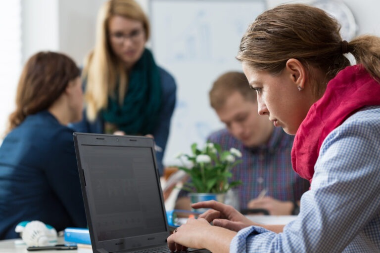 woman working alone around coworkers