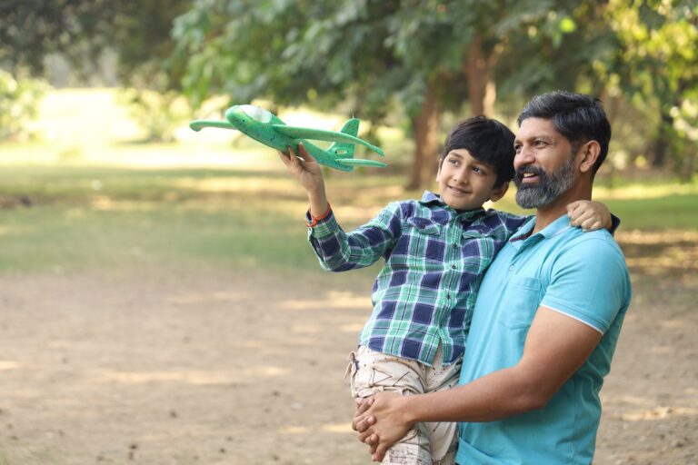 Man holding a child with a toy airplane