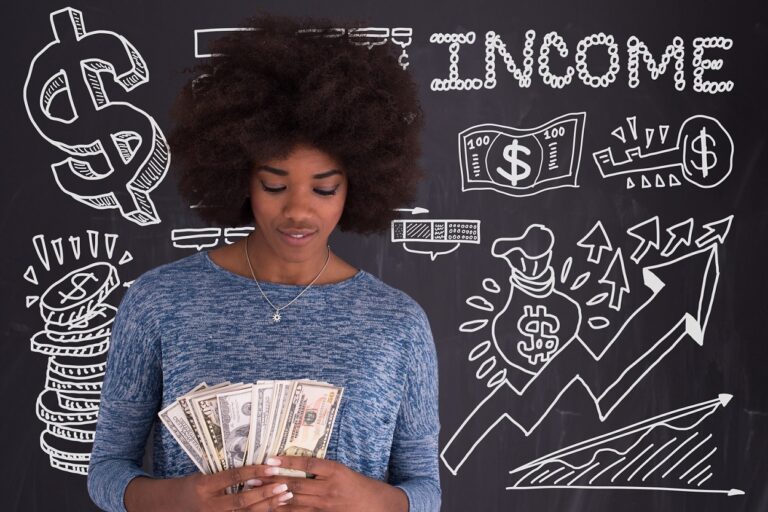 Woman with dollar bills in front of chalkboard with the word income behind her.