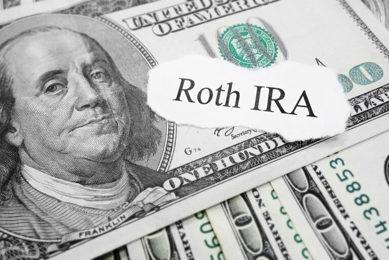 Paper that says Roth IRA on top of dollar bills