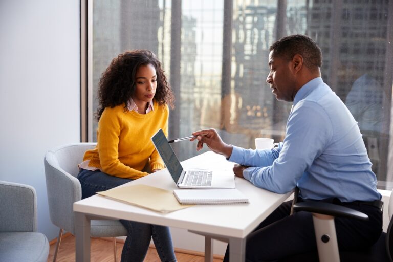 Woman and man in office talking.