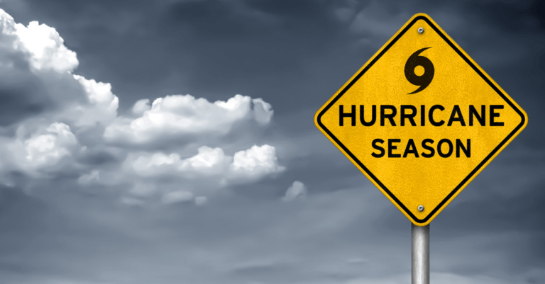 a yellow sign that reads "hurricane season" with a stormy sky in the background