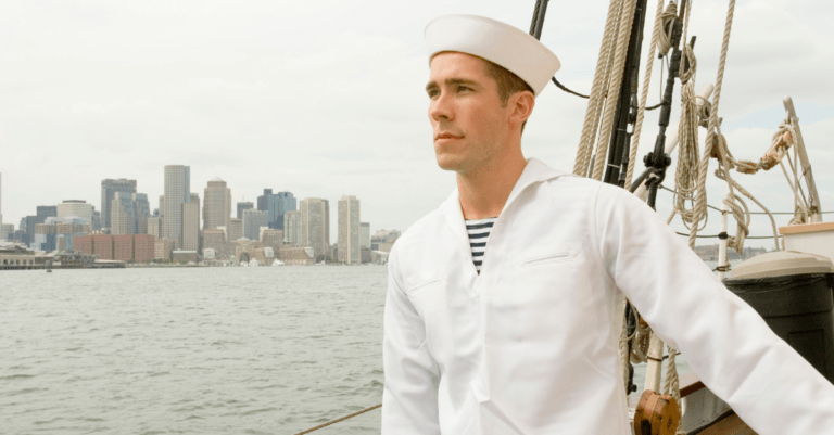 a lone sailor on a boat looking out on the sea