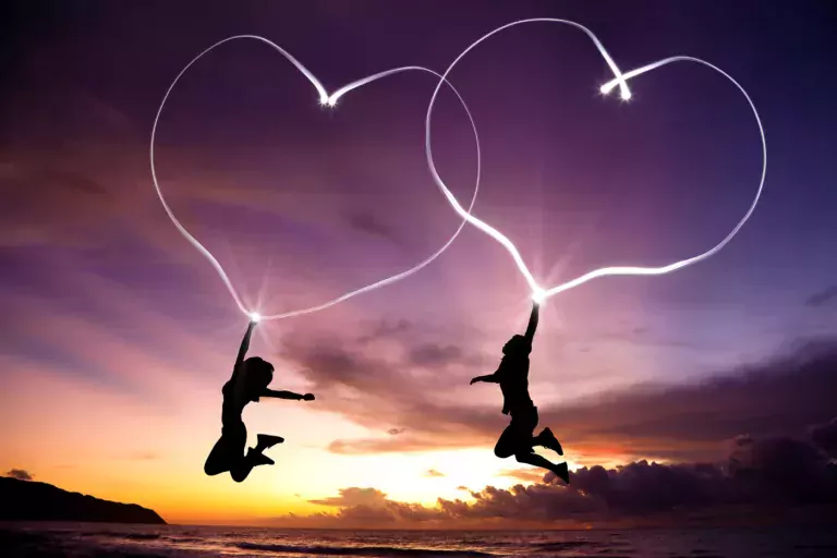Two figures drawing hearts in the sky with electricity