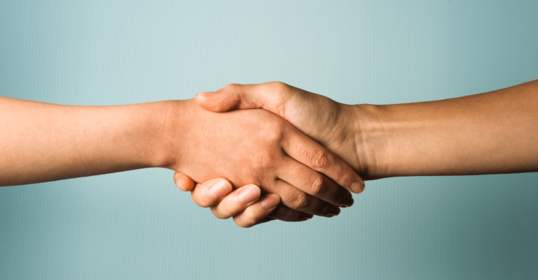 Two isolated hands shaking on a blue background