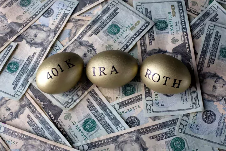 Three gold eggs on dollar bills. Eggs say the words "roth", "401k", and "IRA"