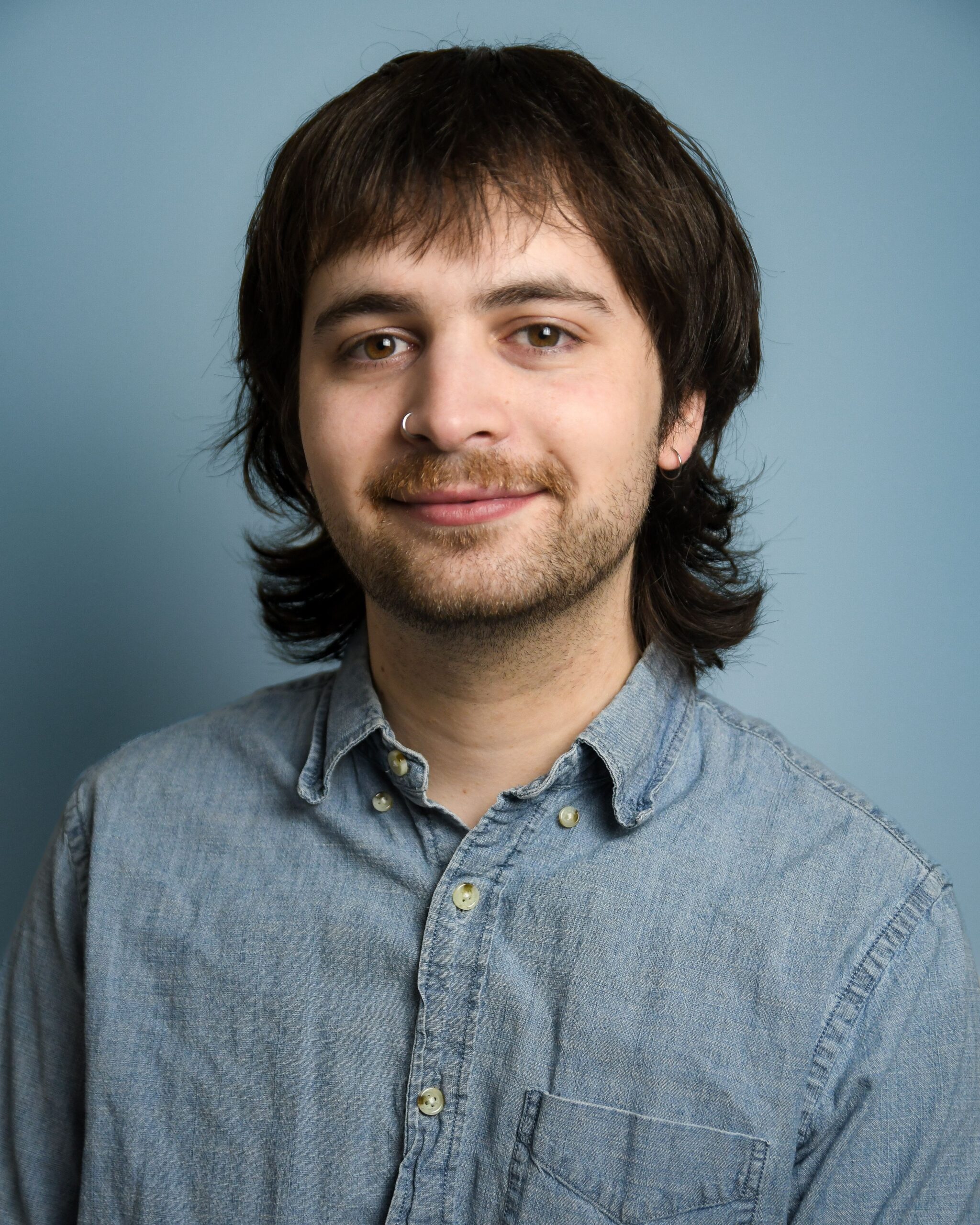 Man with a mustache and beard wearing a blue shirt