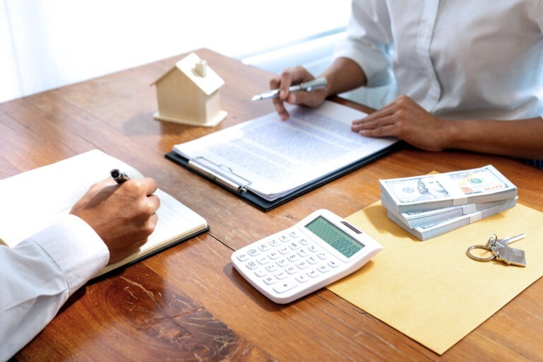 The Quick and Dirty Guide to DSCR Loans for Property Buyers Person with a calculator, graphs and a little house on the table